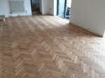 This photo was taken before the lacquer was applied Reclaimed wood flooring pine parquet installed in herringbone style, sanding and finish in Southampton