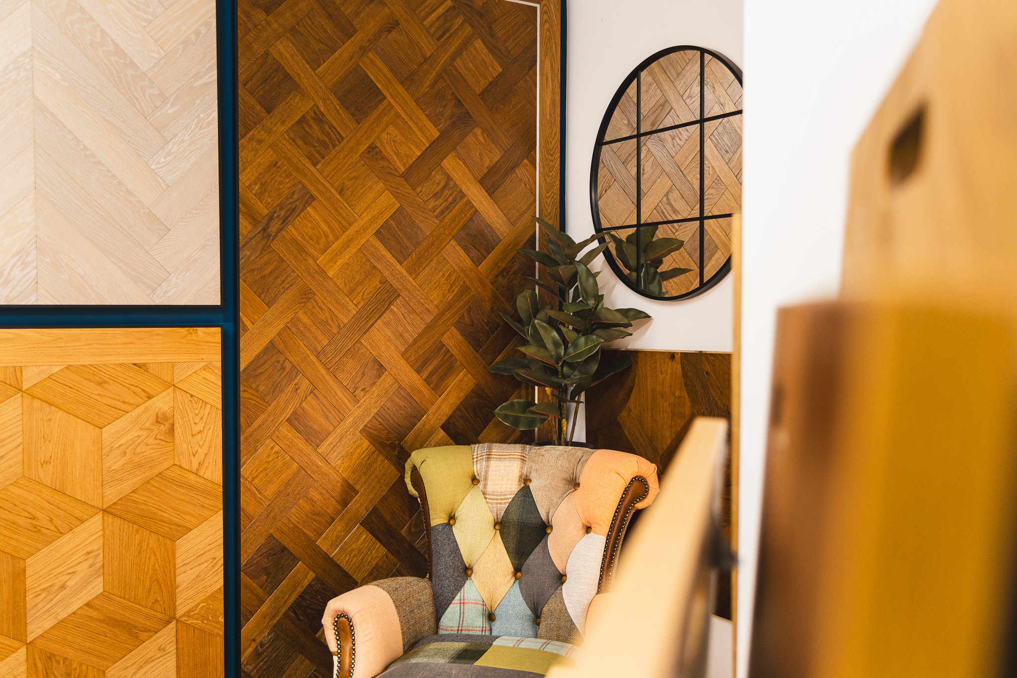 Artistic shot of wood flooring covering walls with colourful chair.