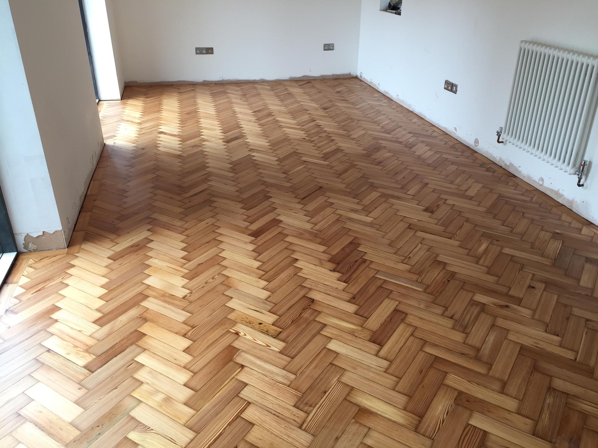 Reclaimed wood flooring pine parquet installed in herringbone style, sanding and finish in Southampton