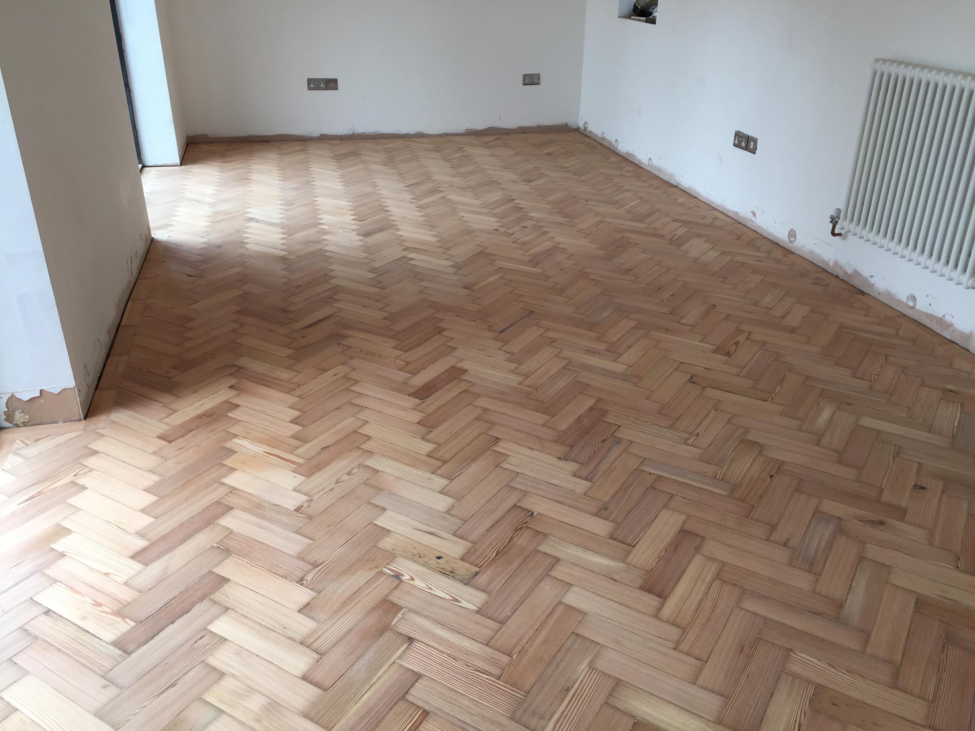 Reclaimed wood flooring pine parquet installed in herringbone style, sanding and finish in Southampton