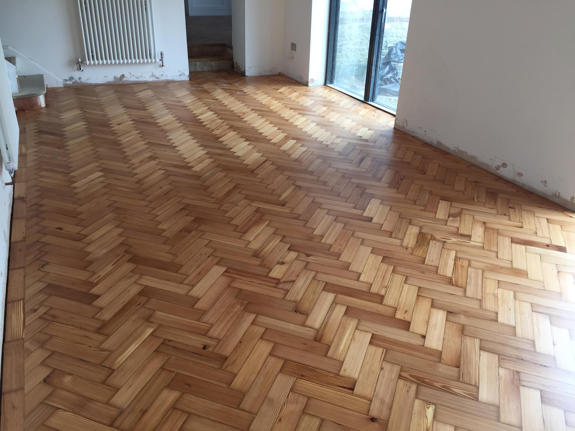 Reclaimed wood flooring pine parquet installed in herringbone style, sanding and finish in Southampton