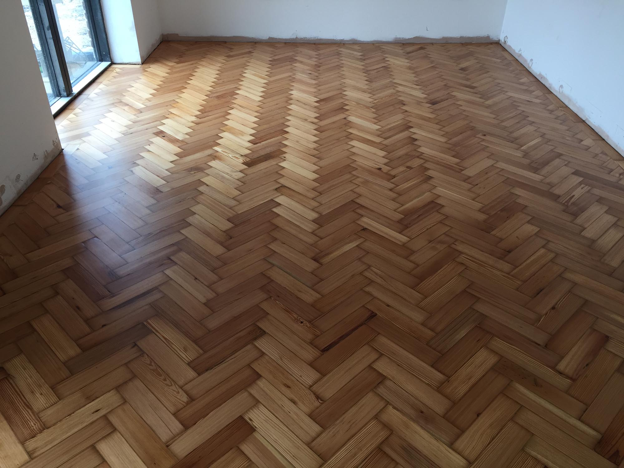 Reclaimed wood flooring pine parquet installed in herringbone style, sanding and finish in Southampton