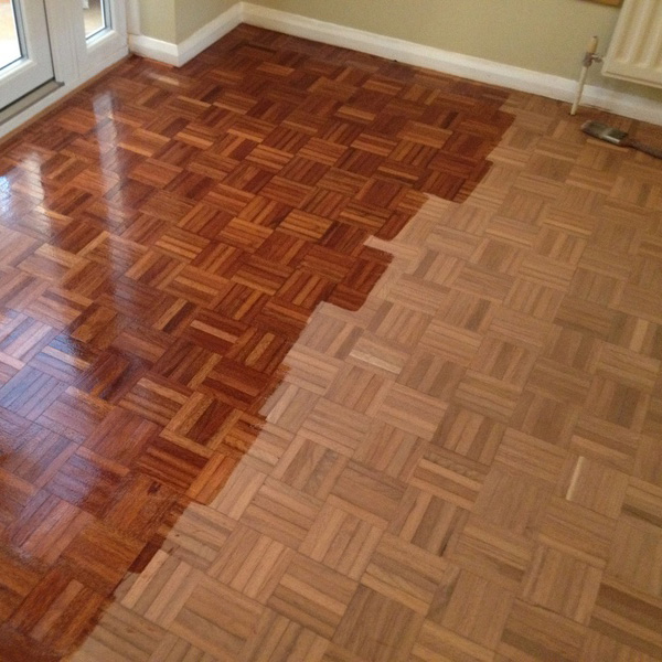 Parquet floor during refinishing process with only half the floor completed.