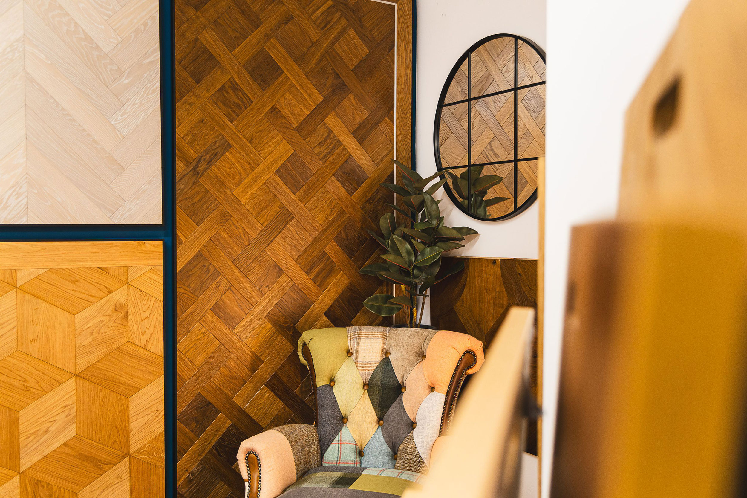 Artistic shot of salisbury wood floors showroom with large flooring samples on the wall, a mirror and colourful chair in the corner.