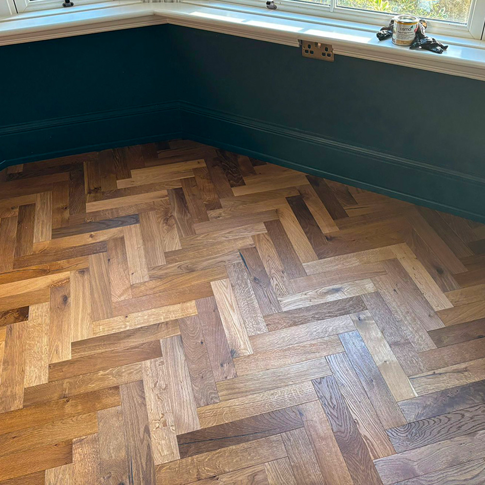 Close up of oak herringbone flooring in front room.