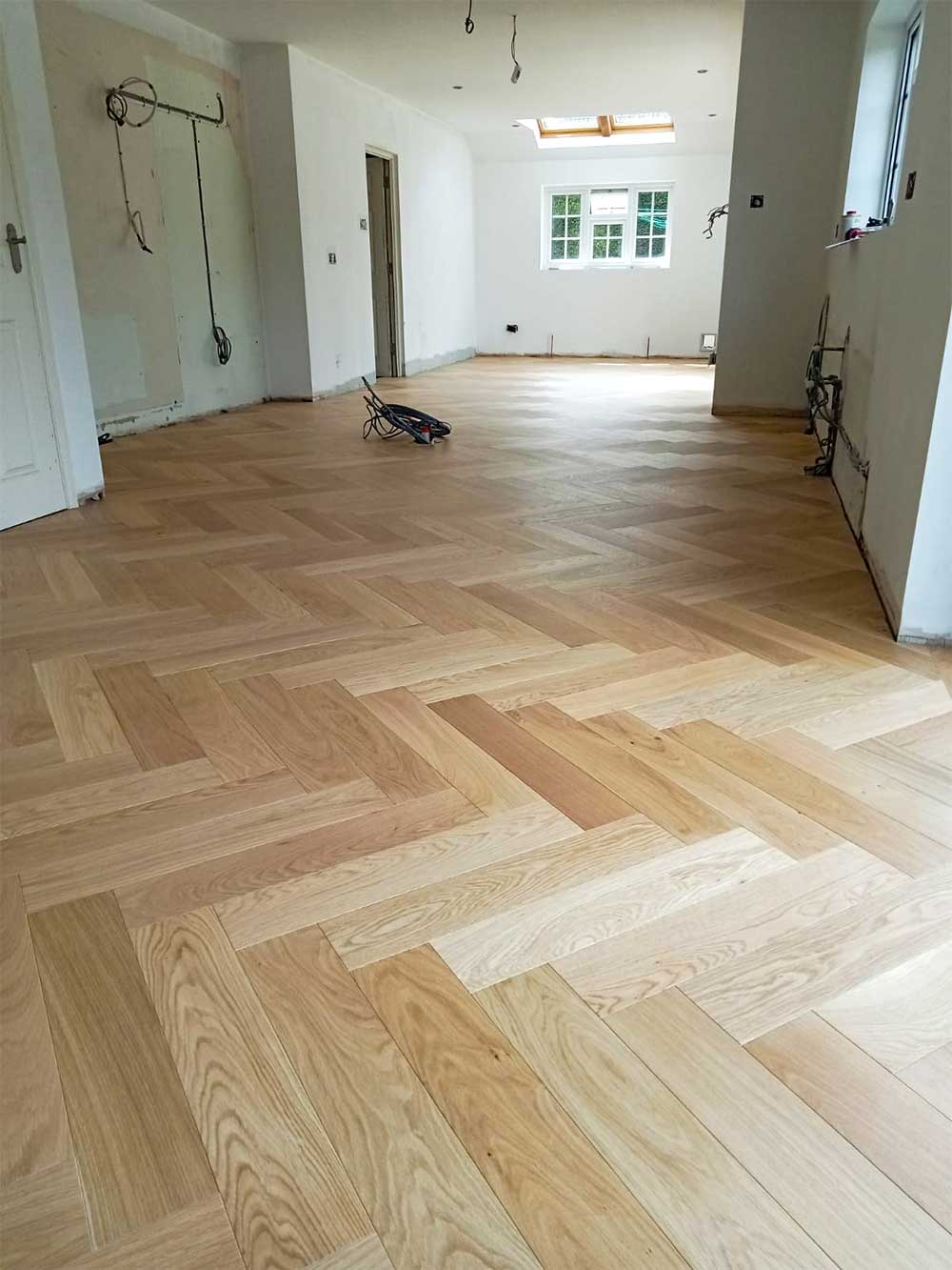 Large prime grade oiled oak herringbone parquet supplied and fitted in living room area.