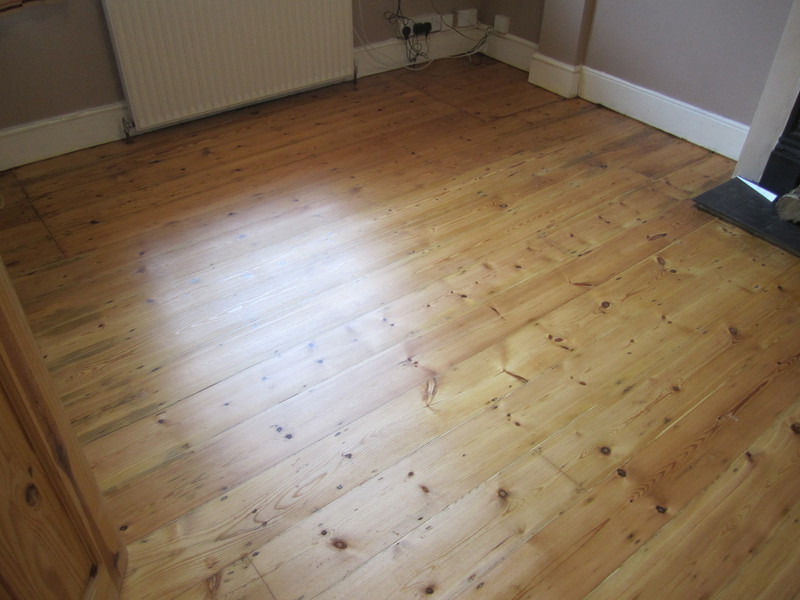 Floorboards using wood slivers for gap filling finished and restored.
