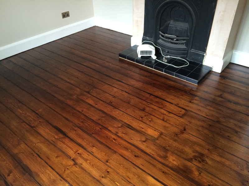 Floorboards completed following sanding and staining with a dark tone finish.