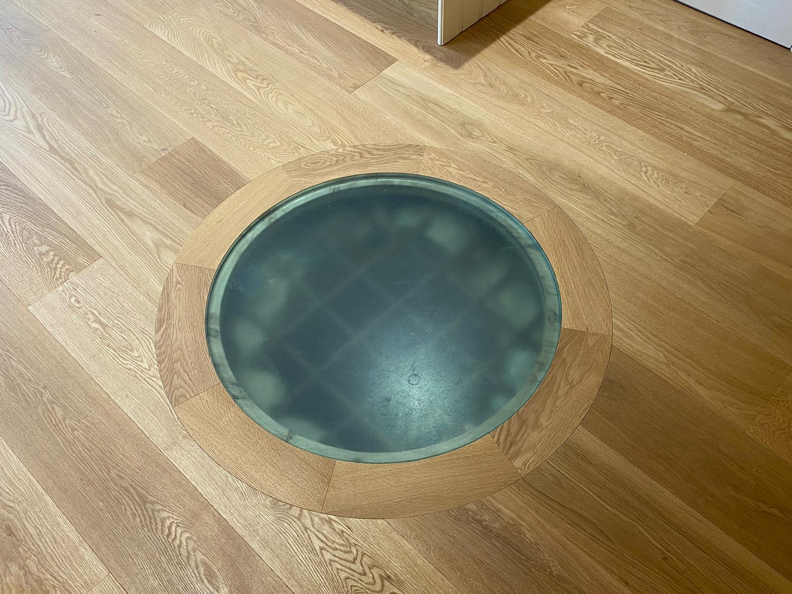 Supplied and fitted plank wood floor with a circular glass detail in the middle.