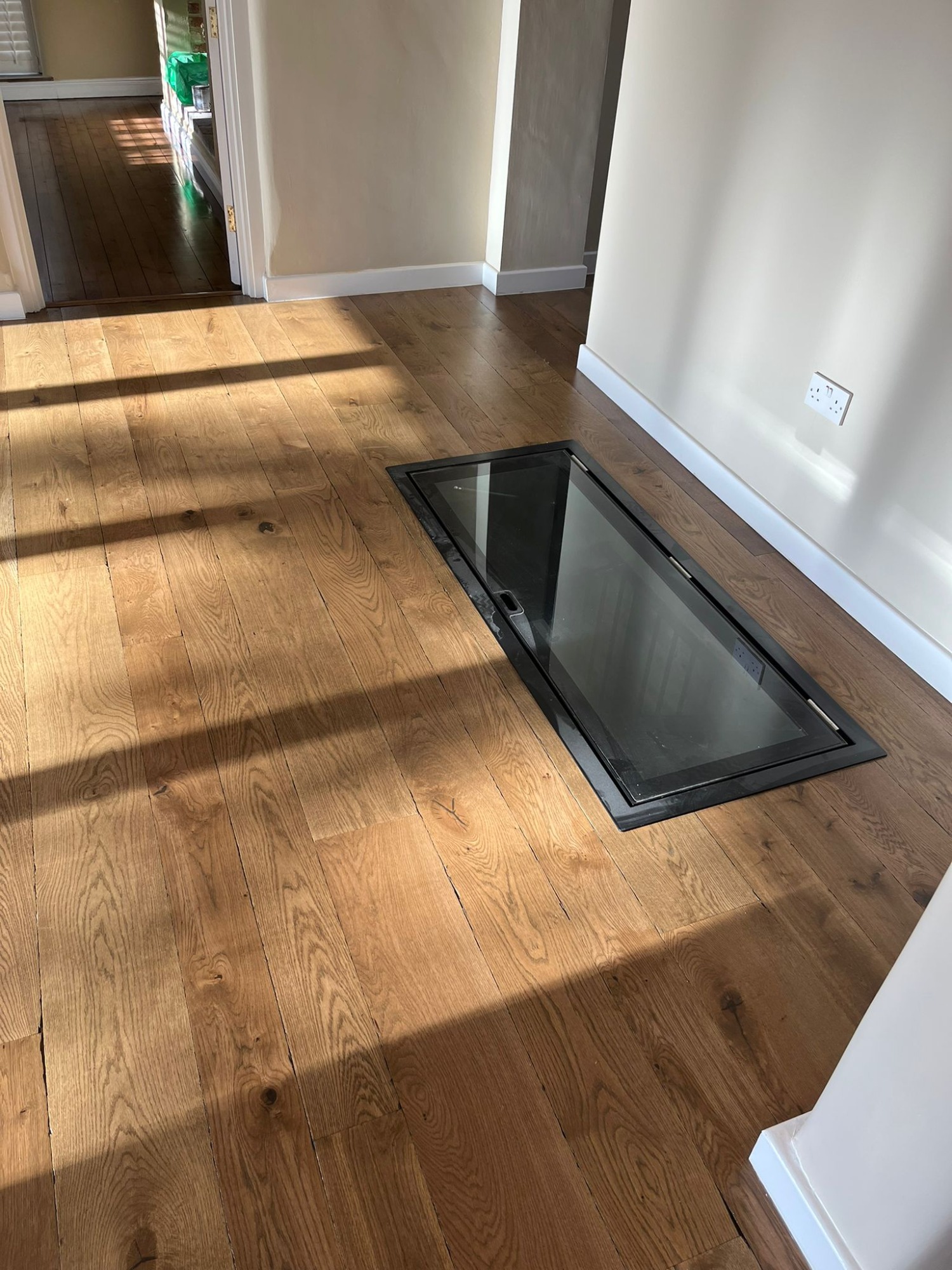 Wood floor with a glass door leading to wine cellar.