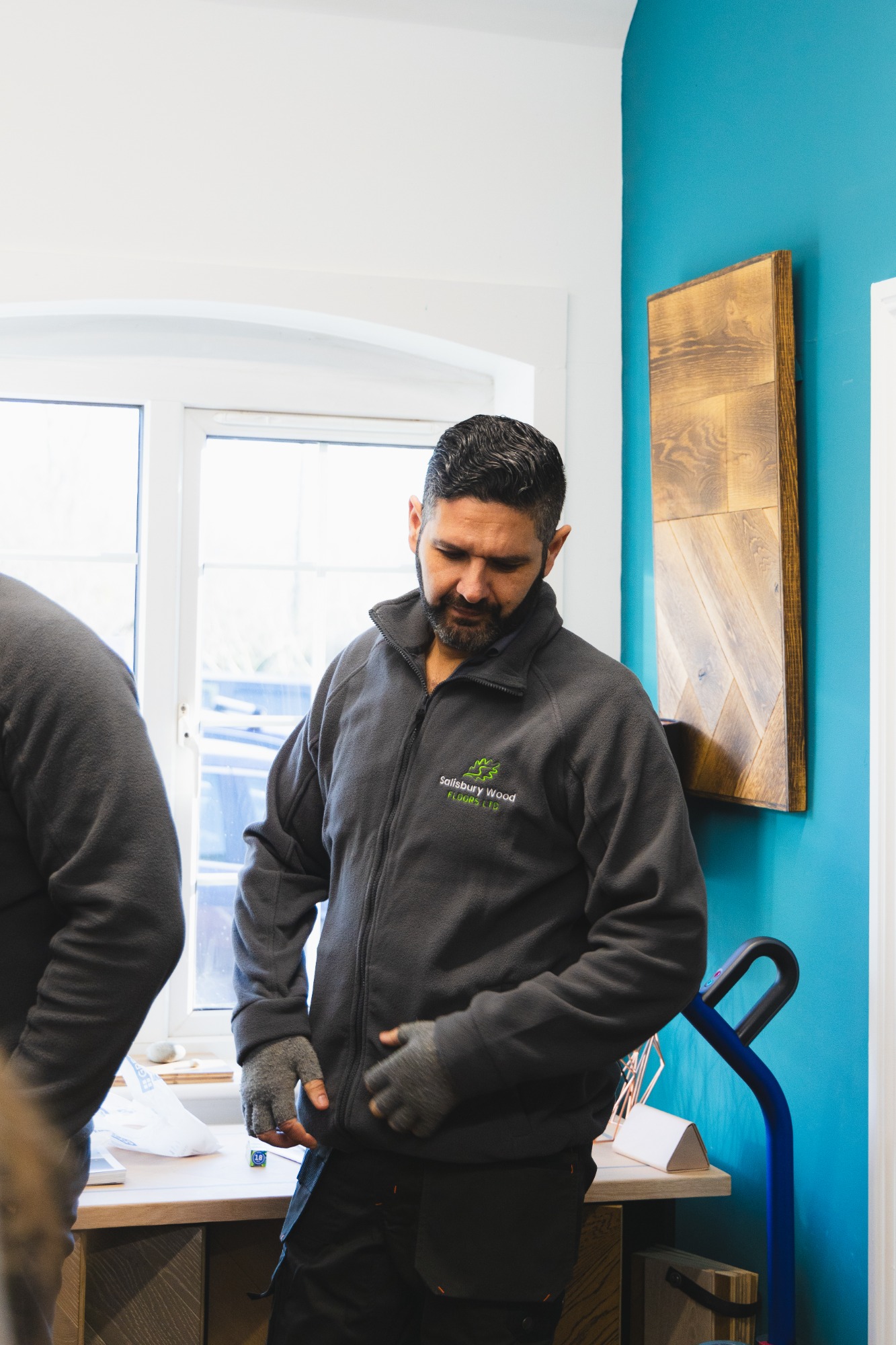 Salisbury wood floor team member with dark hair and wearing fingerless gloves.