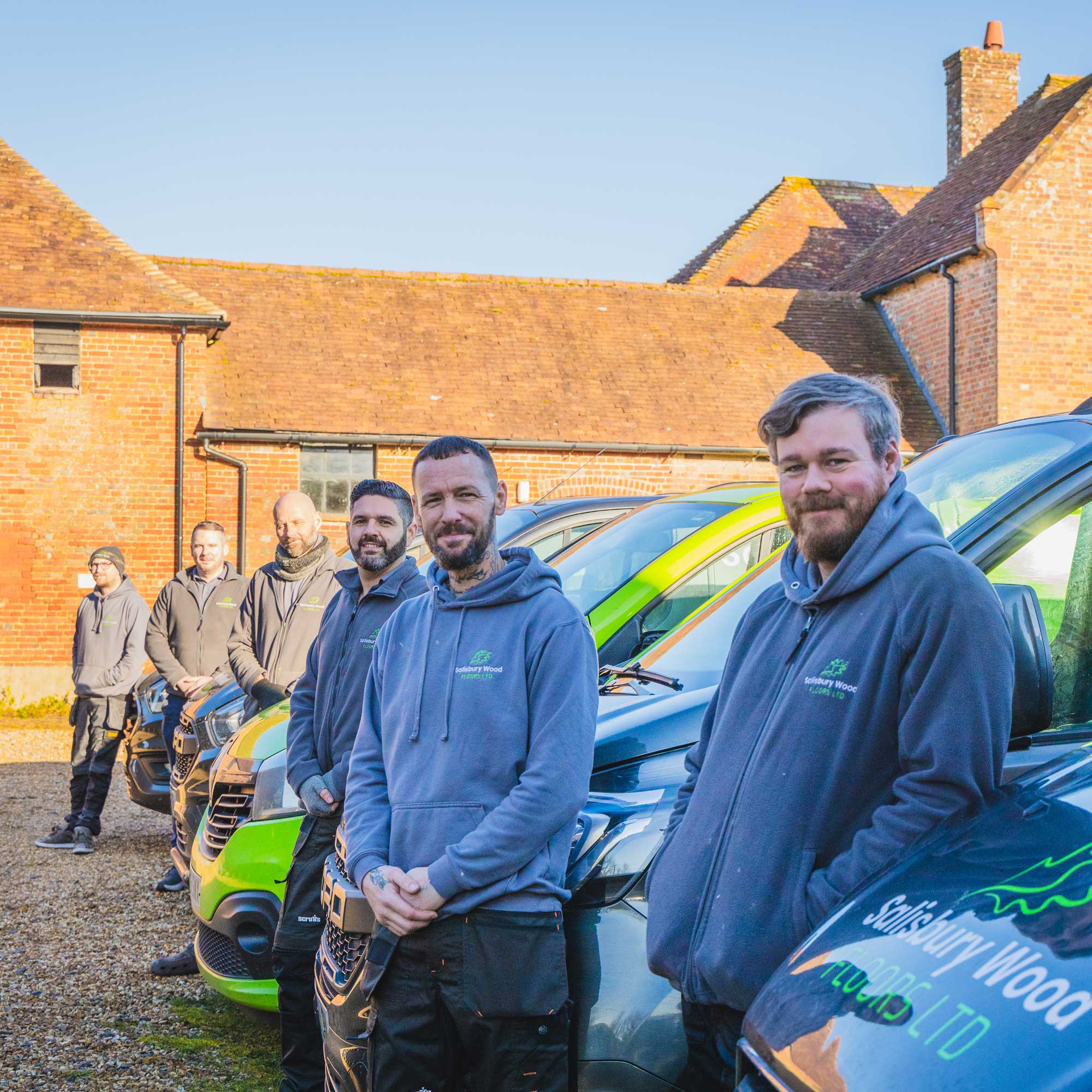 Salisbury wood floors team posing for a photo in front of their vans.