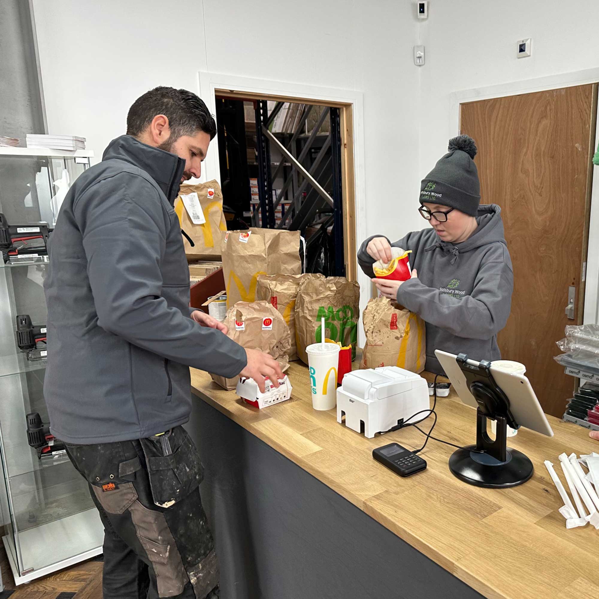 Two salisbury wood floors team members opening a mcdonalds dressed in warm clothing.