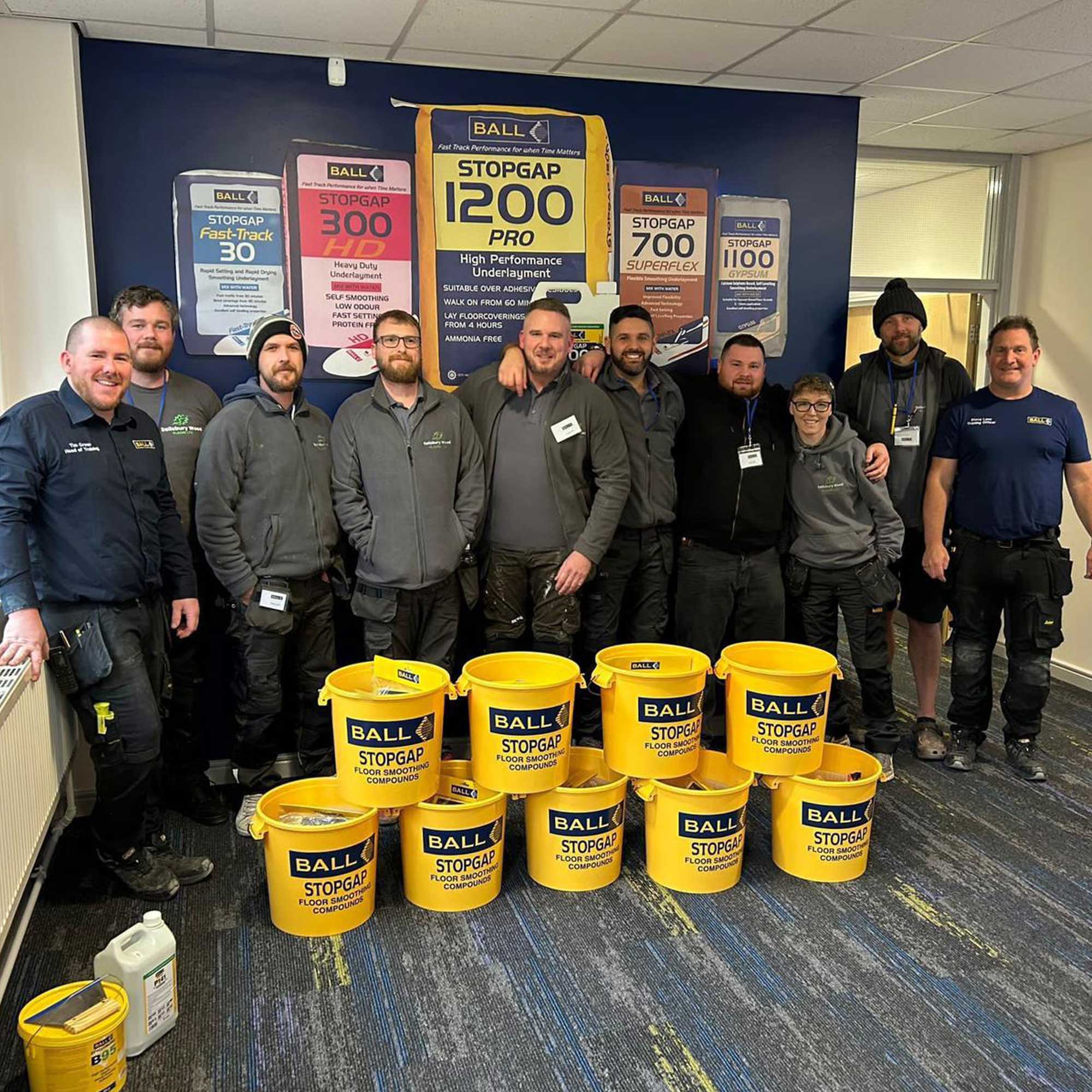 Salisbury wood floors team at an f ball training day. having a group photo with products.