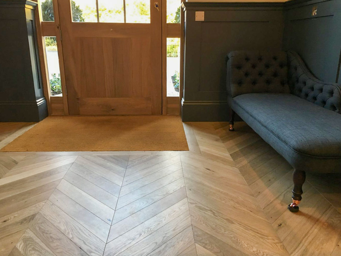 Close up of inset coir matt installed at front of home showing parquet floor surrounding it.