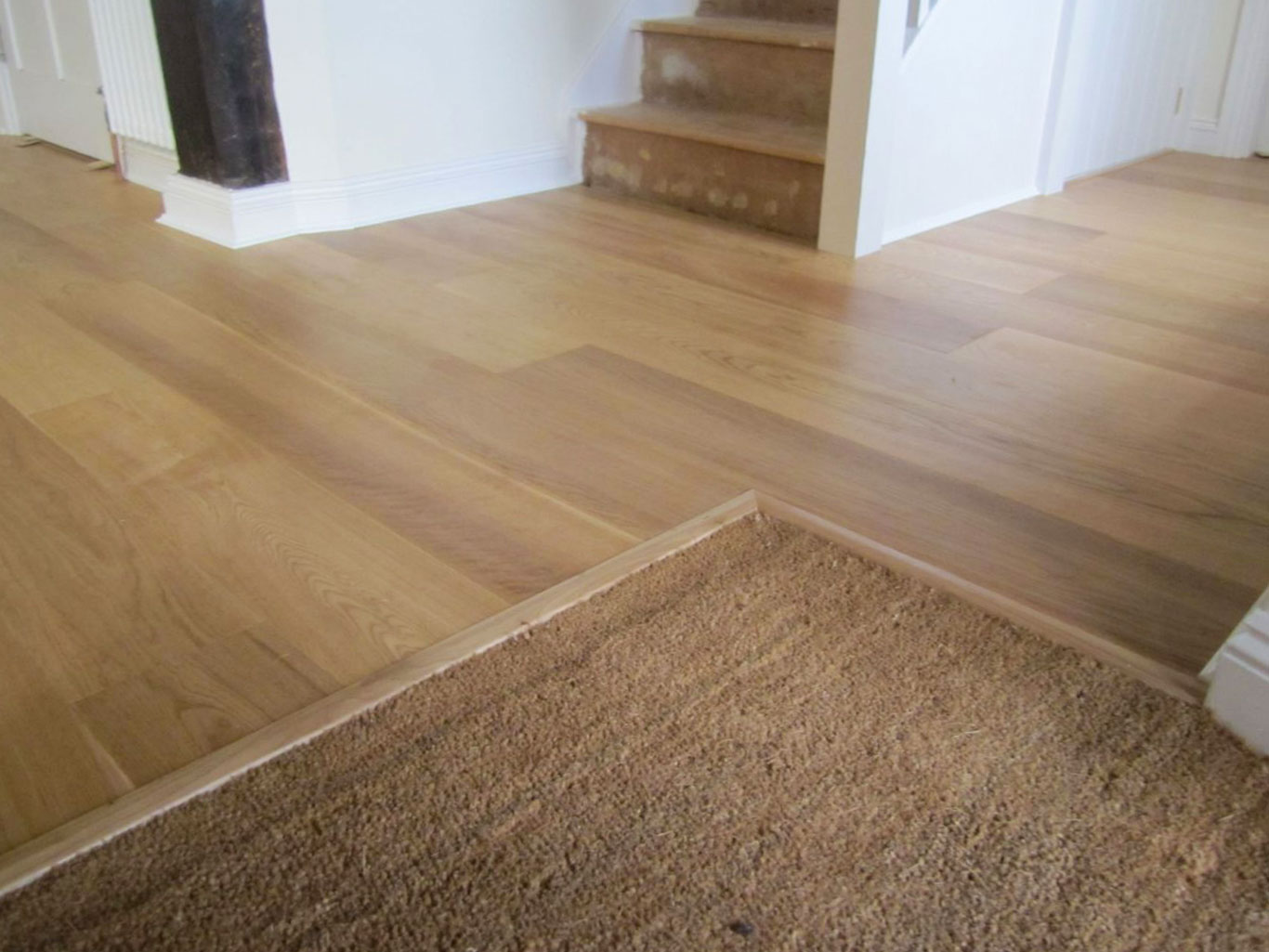 Close up of inset coir matt installed at front of home showing how it's blended into installed wood floor.