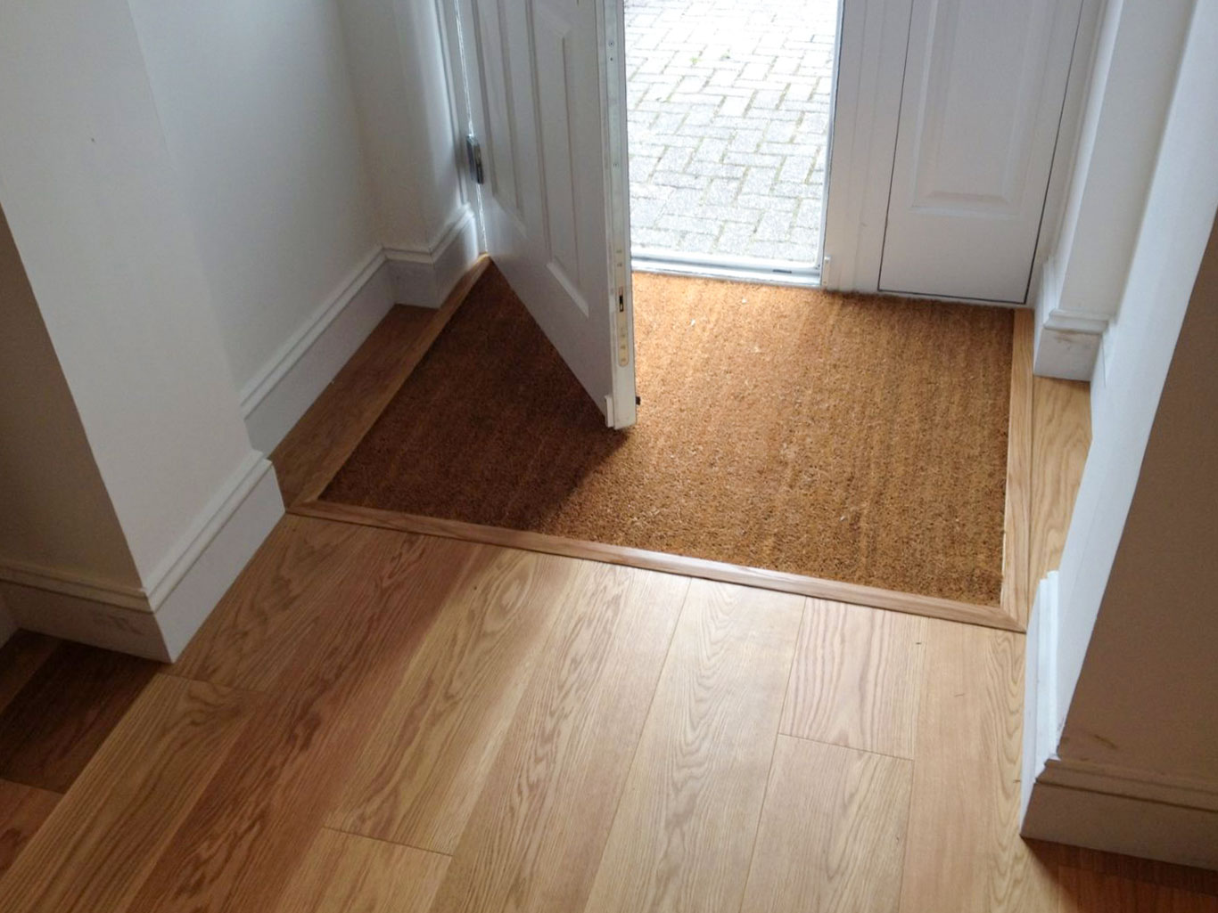 Inset coir matt installed at front of home blended into wooden floor.