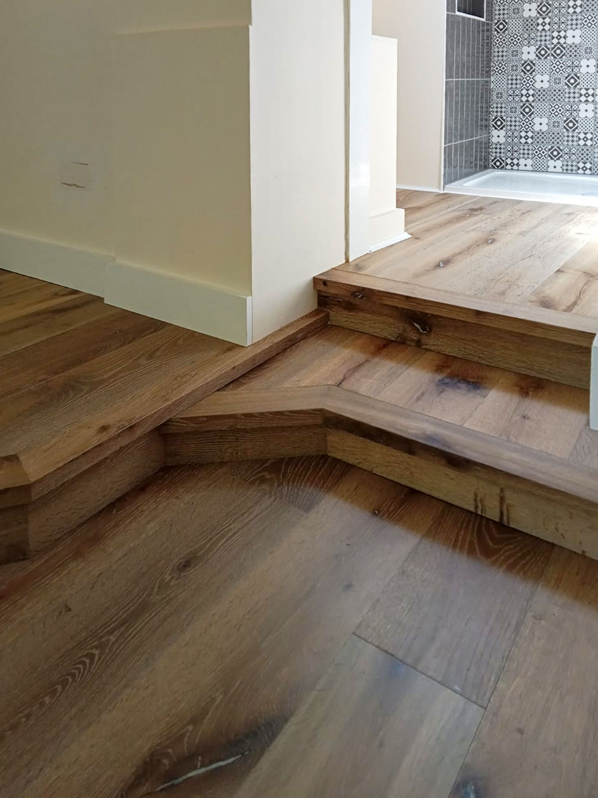 Complex stair cladding installed in upstairs area of a home in plank style.