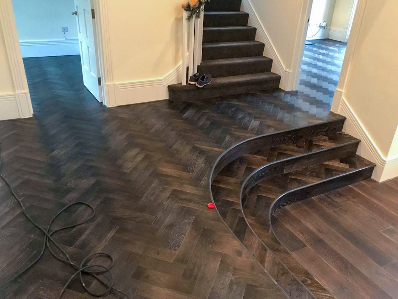 Supplied and installed parquet stair cladding in living room area in dark tone.
