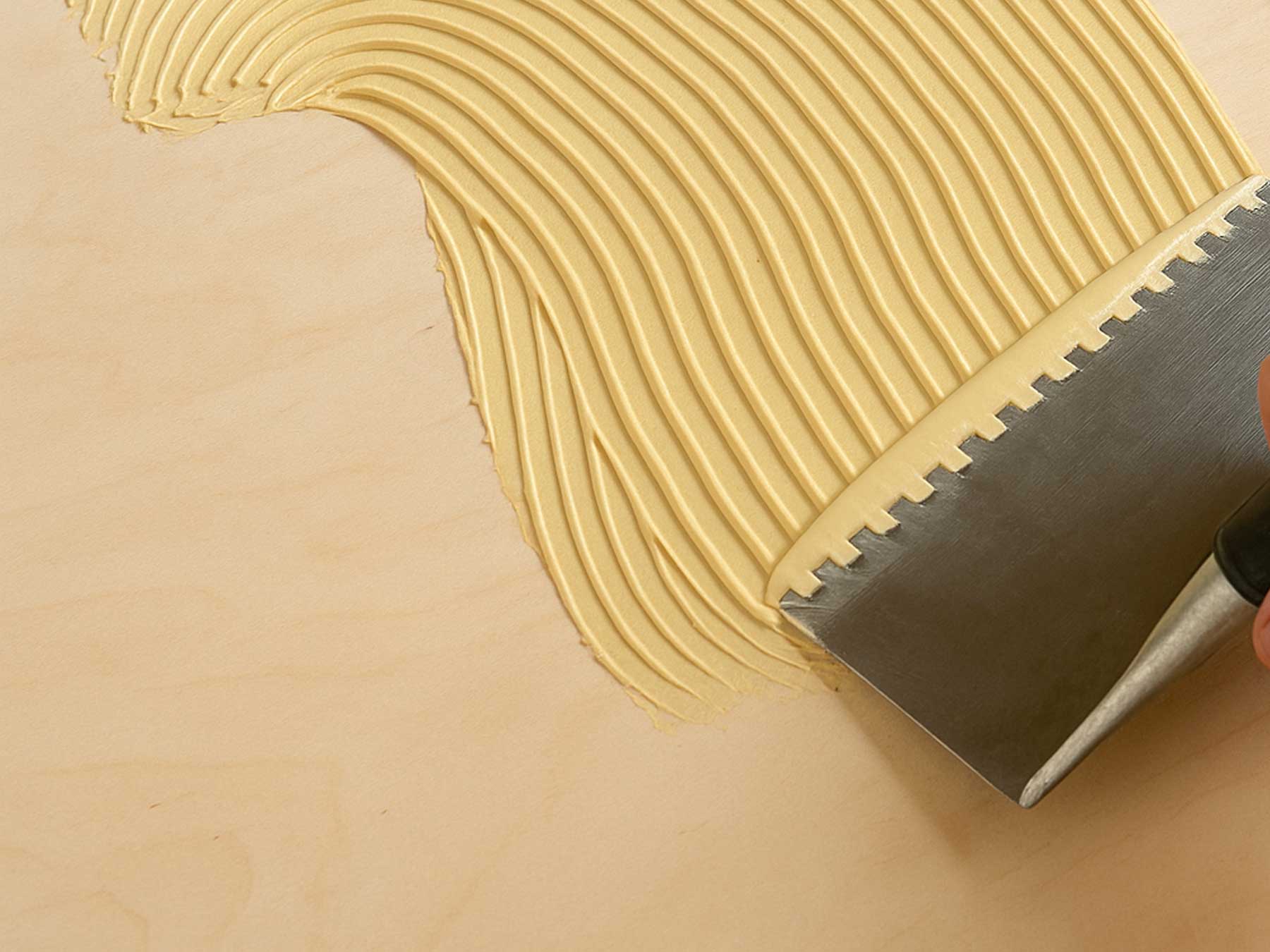 Close up of glue adhesive being applied to the floor.