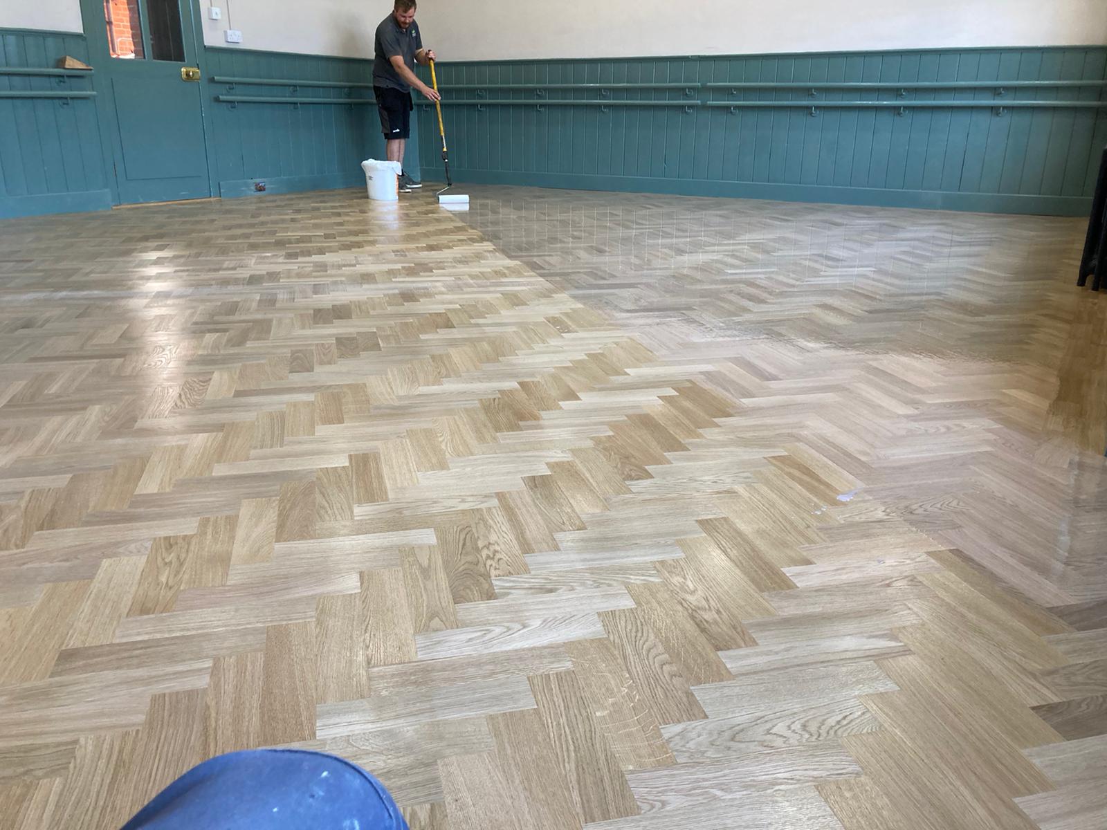 Wood floor being lacquering by salisbury wood floor employee.