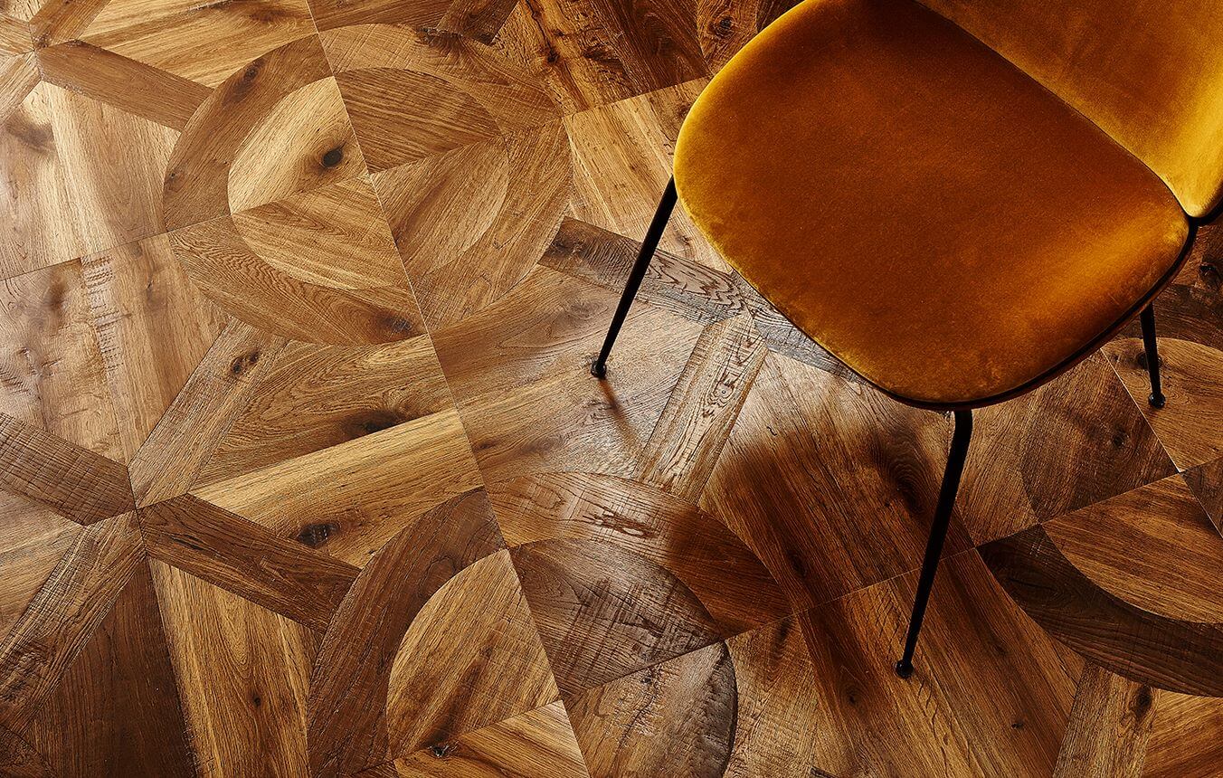 Panel wood flooring in room with an orange chair in the top right corner.