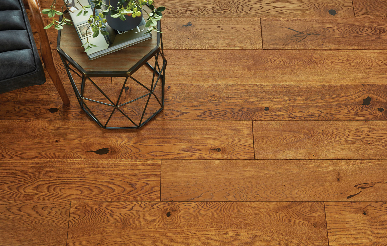 Plank wood flooring in room setting with metal side table in top left corner.